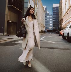 a woman is walking down the street with her handbag