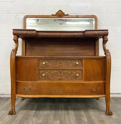 an old wooden dresser with a mirror on it's top and drawers below the drawer