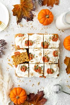 pumpkin spice cake with white frosting and oranges on the table next to it