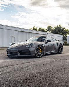 a grey sports car parked in front of a building