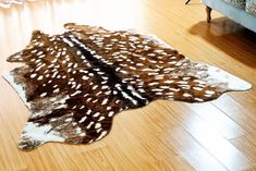 a brown and white animal print rug on the floor in a living room with hardwood floors