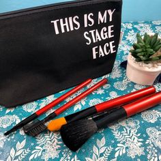 this is my stage face brush and makeup bag on a table with succulents