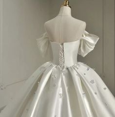 a white wedding dress on display in front of a mannequin's head