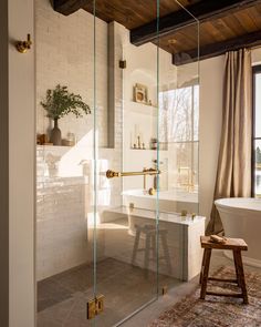 a bathroom with a bathtub, stool and window