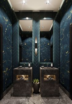 two sinks and mirrors in a room with blue tiles on the walls, along with lights