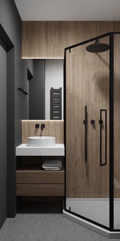 a bathroom with a walk in shower next to a white sink and wooden counter top