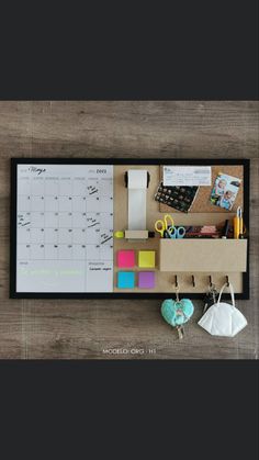 an overhead view of a desk with various items on it and a calendar attached to the wall