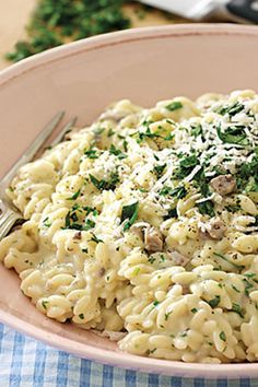 a bowl filled with macaroni and cheese covered in parmesan