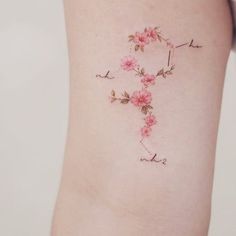 a woman's lower thigh with pink flowers and the word love written in cursive writing