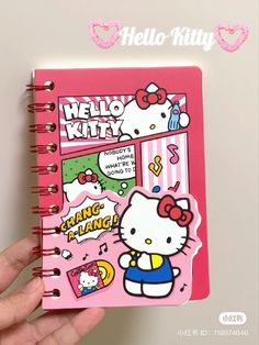 the hello kitty notebook is pink and has cartoon characters on it