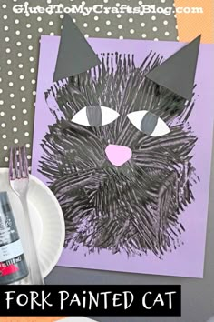 a paper plate with a black cat on it next to an art project for kids