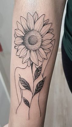 a woman's arm with a sunflower tattoo on it