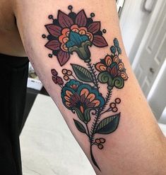 a woman's arm with flowers and leaves tattooed on the left side of her body