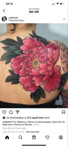 the back of a woman's shoulder with pink flowers on it and green leaves