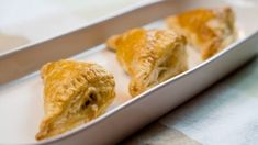 three pastries in a metal tray on a table