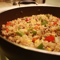 a pan filled with rice and vegetables on top of a stove