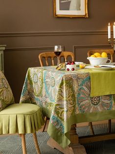 a table with two chairs and a bowl of fruit on it