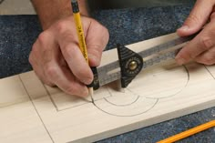 a man working on a piece of wood with a measuring tape and a pair of scissors