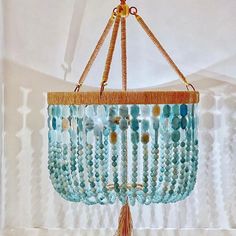 a chandelier with beads hanging from it's sides and a tasseled handle