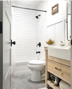 a white toilet sitting next to a bath tub in a bathroom on top of a tiled floor