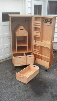 an open wooden cabinet sitting on top of a driveway