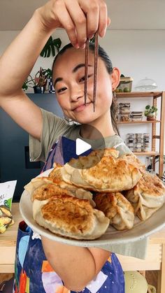 a woman holding a plate with pancakes on it