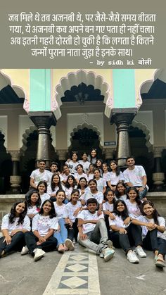 a group of people posing for a photo in front of a building with a quote on it