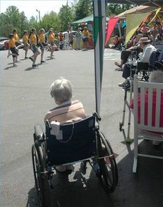 an elderly woman in a wheel chair under a tent