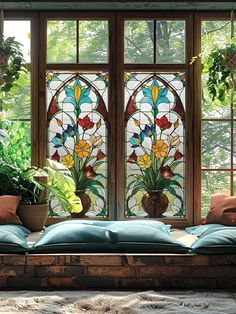 a stained glass window with potted plants in front of it and on the floor