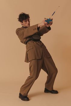 a man in a brown suit holding a blue object