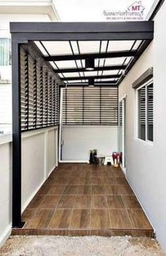 an outdoor covered patio with wood flooring and white walls