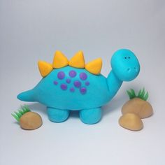 a blue toy dinosaur with a yellow crown on its head