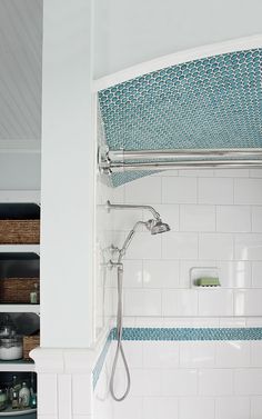 the shower head is connected to the faucet in this white and blue bathroom