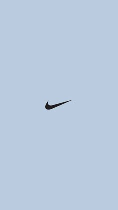 a black nike logo on a blue sky with no clouds in the backround