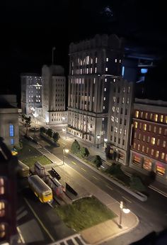 an aerial view of a city at night with buildings and street lights in the foreground