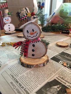 a snowman made out of wood sitting on top of a newspaper next to other decorations