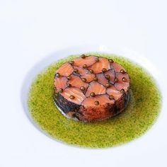 a plate with some kind of food on it that is covered in green sauce and garnishes