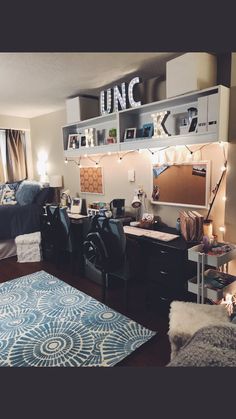 a bedroom with a bed, desk and shelves on the wall next to a window