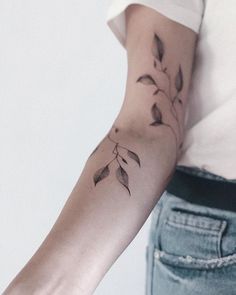 a woman's arm with leaves on it