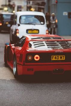 a red sports car driving down the street