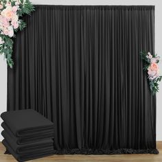 the backdrop is black and has flowers on it, along with two large drapes