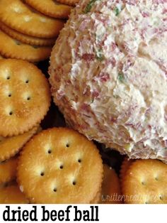 crackers are arranged around a cheese ball on a platter filled with crab salad