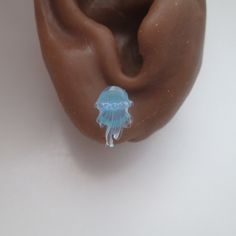 Made from slightly iridescent blue resin, these jellyfish earrings can be made either as no pierce invisible clip on earrings or metal free plastic post studs for metal sensitive pierced ears. Simple, yet elegant, these no pierce earrings are made with comfortable slide on clips that slip onto the earlobe. Just gently pull the front and back apart enough to slide onto your earlobe and carefully release. Lightweight, metal free, and made with findings that apply minimal pressure to the earlobe, these earrings are the most comfortable clip ons around.  Metal free, the plastic post studs are made with easy wear nylon posts for pierced ears. These plastic post studs also come with an extra pair of plain posts for those who want to wear plastic posts while sleeping as sleeping in the regular de Plastic Jellyfish, Jellyfish Earrings, Blue Jellyfish, Kitty Clothes, Iridescent Blue, Ear Piercing, Slide On, Pierced Ears, Jellyfish