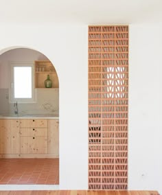 an arch in the wall between two kitchen cabinets and a counter top with a sink