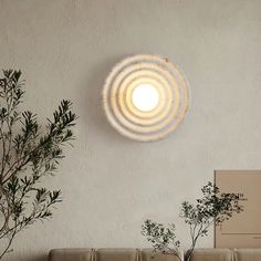 a living room scene with focus on the round light fixture above the couch and potted plant