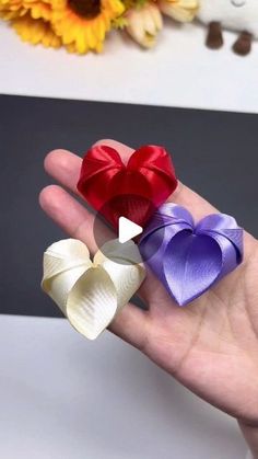 three different colored bows in the palm of someone's hand