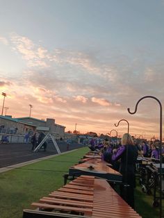 people are sitting at benches on the grass