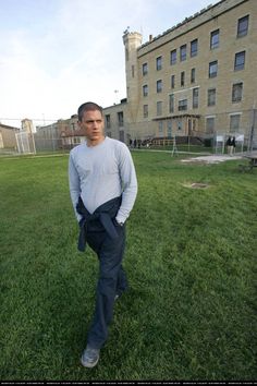 a man standing in the middle of a field with his hand on his hip pocket