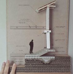 a person holding up a piece of paper with an architectural diagram in front of them