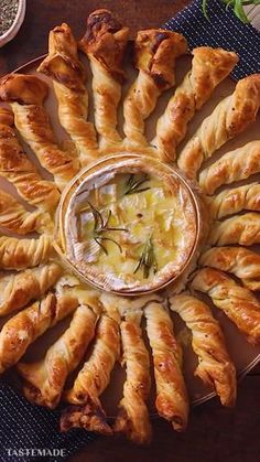 an assortment of pastries arranged in a circle on a plate with dipping sauces